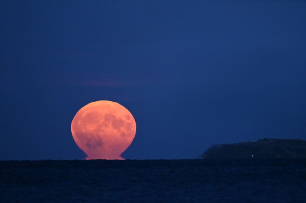 Buck Moon over Oresund Strait in Taarbaek, north of Copenhagen, Denmark, 13 July 2022. Photo by Sergei Gapon/Anadolu Agency via Getty Images