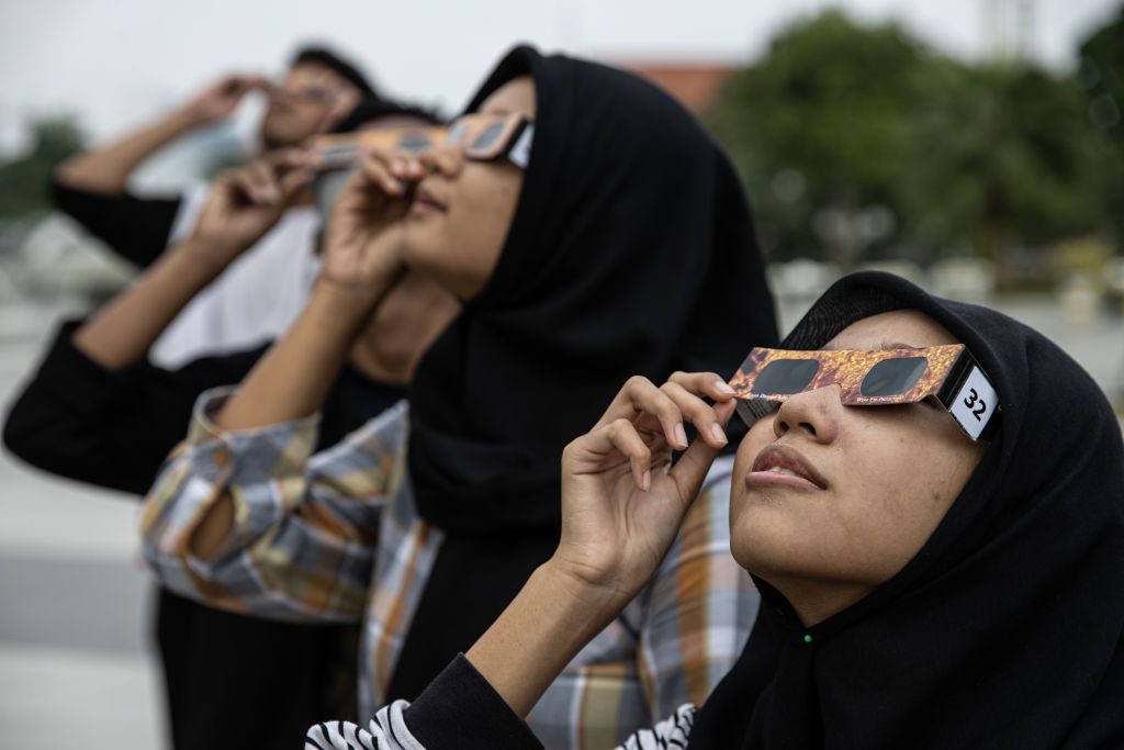 Eclipse chasers in Surabaya , Indonesia observe a hybrid solar eclipse wearing solar eclipse glasses on 20 April 2023. Photo by Robertus Pudyanto/Getty Images Eclipse chasers in Surabaya , Indonesia observe a hybrid solar eclipse wearing solar eclipse glasses on 20 April 2023. Photo by Robertus Pudyanto/Getty Images
