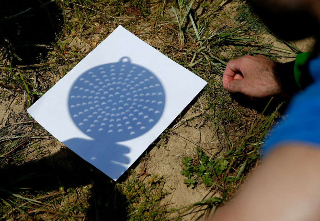 A regular kitchen colander can be used to project an eclipse onto a piece of white paper or card. Photo by Jessica Rinaldi/The Boston Globe via Getty Images A regular kitchen colander can be used to project an eclipse onto a piece of white paper or card. Photo by Jessica Rinaldi/The Boston Globe via Getty Images