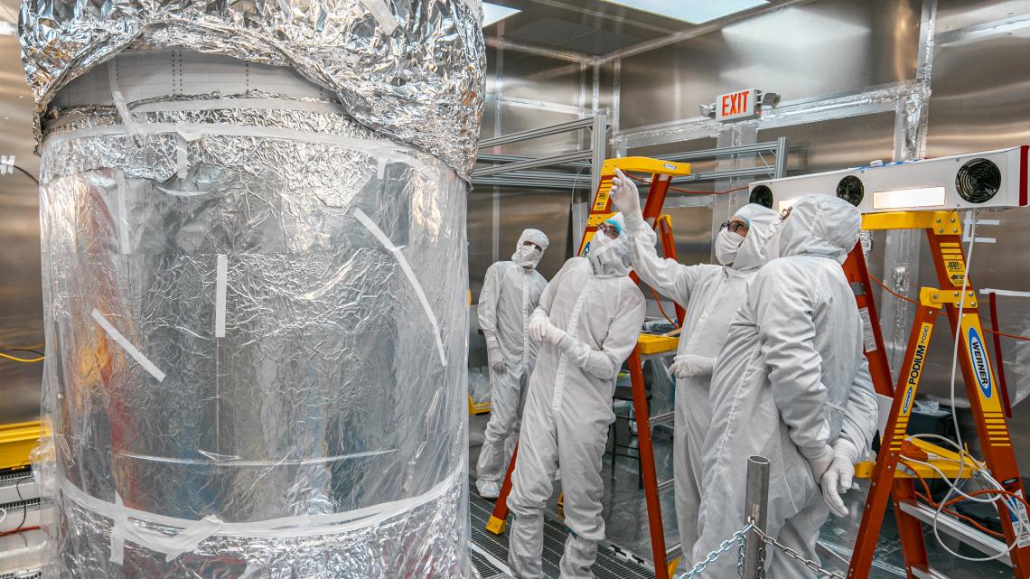 Scientists inspect the newly-assembled LUX-ZEPLIN experiment at the Surface Assembly Lab cleanroom, Sanford Underground Research Facility. Credit: Matthew Kapust, Sanford Underground Research Facility.
