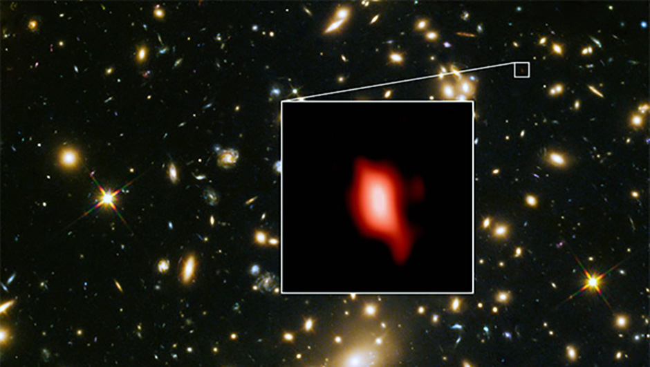 Galaxy cluster MACS J1149.5+2223 in an image captured with the Hubble Space Telescope. Inset is galaxy MACS1149-JD1, seen by ALMA as it existed 13.3 billion years ago. Red shows the distribution of oxygen; the most distant ever detected. Image Credit: ALMA (ESO/NAOJ/NRAO), NASA/ESA Hubble Space Telescope, W. Zheng (JHU), M. Postman (STScI), the CLASH Team, Hashimoto et al.