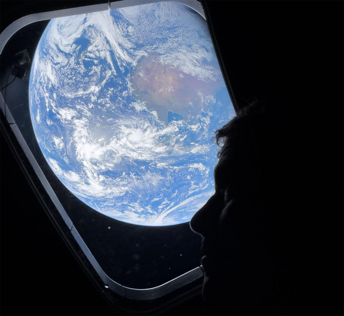 NASA astronaut and Artemis II Commander Reid Wiseman looking out one of the windows of the Orion spacecraft at Earth. Credit: NASA