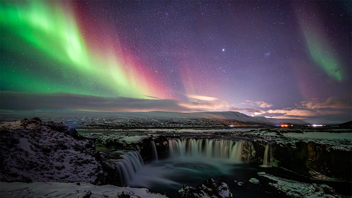 Colourful Aurora and Waterfall © Yifan Cao (China), Best Newcomer. Taken with a Nikon Z 6III camera, 16 mm f/2.2, ISO 4000, 6-second exposure. Location: Goðafoss Waterfall, Þingeyjarsveit, Iceland, 27 February 2025