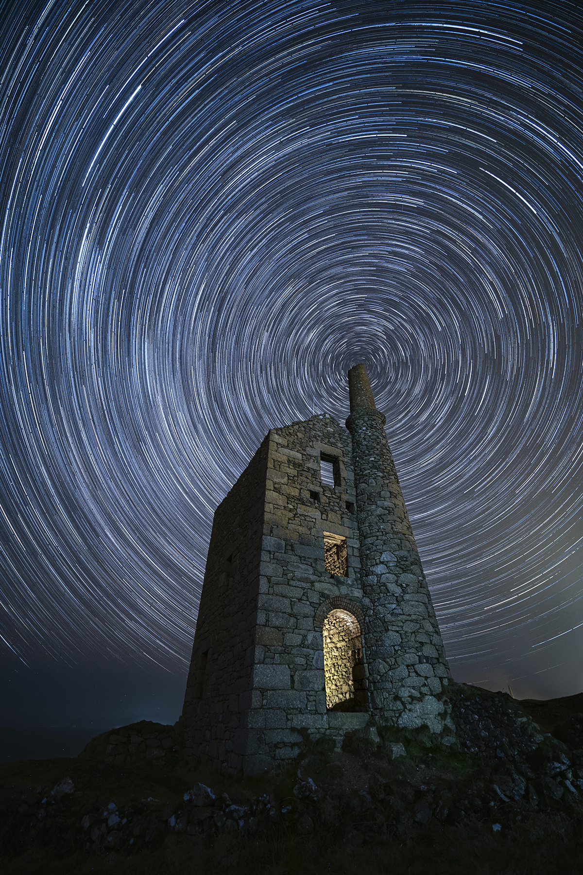 Vortex © Jennifer Rogers (UK), People and Space category. Taken with a Canon EOS 5D Mark IV camera, 14 mm f/2.8, ISO 1600, Foreground: 1 x 60-second exposure; Star trail: 72 x 60-second exposures. Location: West Wheal Owles, Cornwall, England, 22 February 2025
