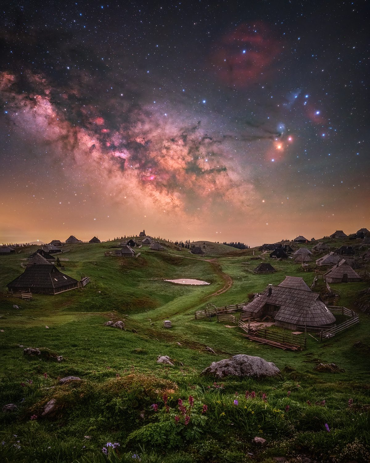 Fairyland © Uroš Fink (Slovenia), People and Space category. Taken with an astro-modified Nikon Z 6II camera, Move Shoot Move Nomad star tracker, 20 mm, Foreground: f/2.0, ISO 1600, 8 x 60-second focus-stacked exposures; Sky: f/2.0, ISO 800, 5 x 60-second exposures. Location: Velika Planina, Kamnik-Savinja Alps, Slovenia, 28 April 2025