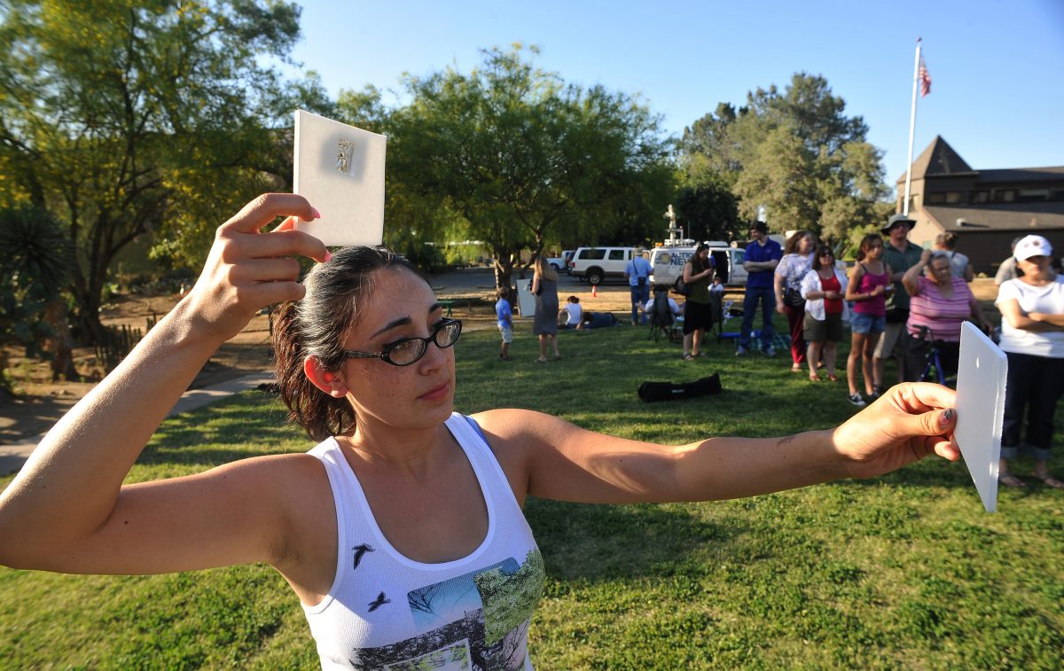 A woman projects a pinhole image of a solar eclipse through a piece of tin foil on to paper, California, 20 May 20 2012. Credit: John Walker/Fresno Bee/Tribune News Service via Getty Images. A woman projects a pinhole image of a solar eclipse through a piece of tin foil on to paper, California, 20 May 20 2012. Credit: John Walker/Fresno Bee/Tribune News Service via Getty Images.