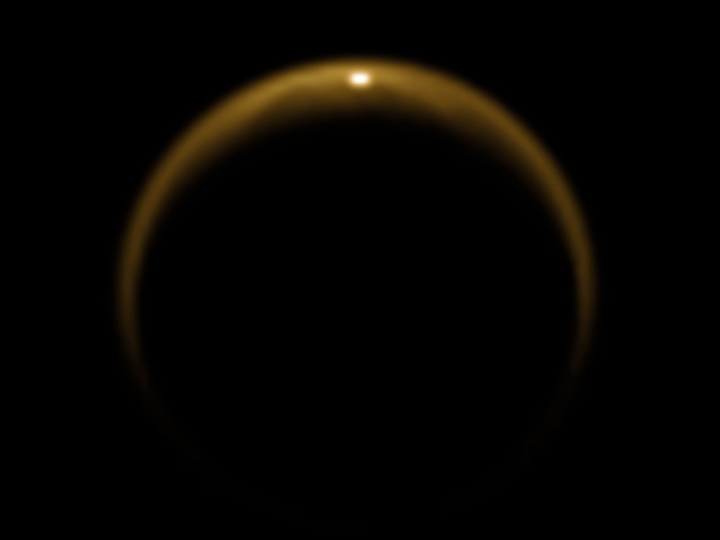 An image of Titan captured by the Cassini spacecraft on July 2009. The bright spot at the top of Titan’s disc is sunlight reflecting off the surface of a hydrocarbon lake. Credit: NASA/JPL/University of Arizona/DLR