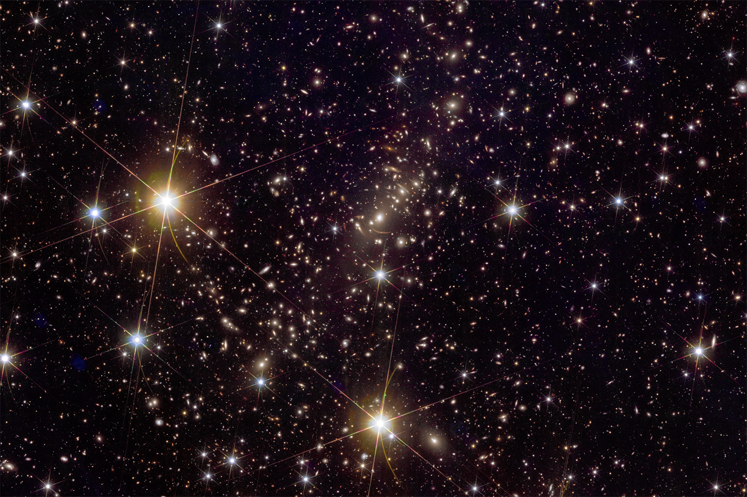 Cutout of the Euclid image of Abell 2390, a galaxy cluster 2.7 billion lightyears away in the constellation of Pegasus. The red arcs show the gravitational lensing of a distant galaxy. Credit: ESA/Euclid/Euclid Consortium/NASA, image processing by J.-C. Cuillandre (CEA Paris-Saclay), G. Anselmi; CC BY-SA 3.0 IGO or ESA Standard Licence.