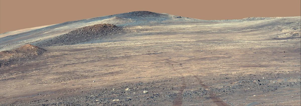 NASA’s Perseverance rover captured this image showing its own tracks descending from the rim of Jezero Crater. Bright rocks running from middle left to middle right are 'Broom Point member' likely more than 3.9 billion years old and among the oldest terrain ever examined by a Mars rover. Credit: NASA/JPL-Caltech/ASU/MSSS