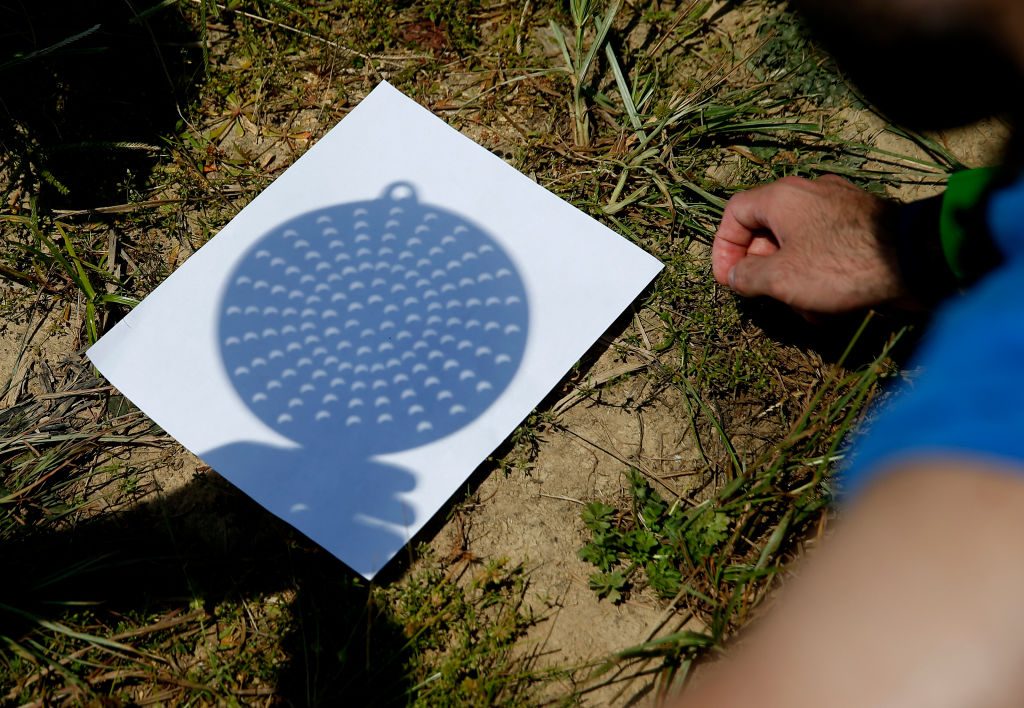 A regular kitchen colander can be used to project an eclipse onto a piece of white paper or card. This would be an easy way photographing the August 2026 solar eclipse. Photo by Jessica Rinaldi/The Boston Globe via Getty Images