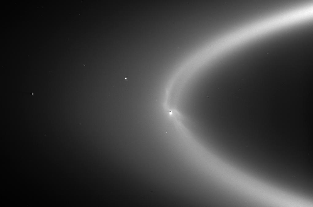 A 2006 observation of Saturn's E ring by the Cassini spacecraft. The E ring is fed with icy particles via plumes erupting from the subsurface ocean of Saturn's icy moon Enceladus. The moon's shadow is seen as a dark dot within the ring. Credit: NASA/JPL/Space Science Institute