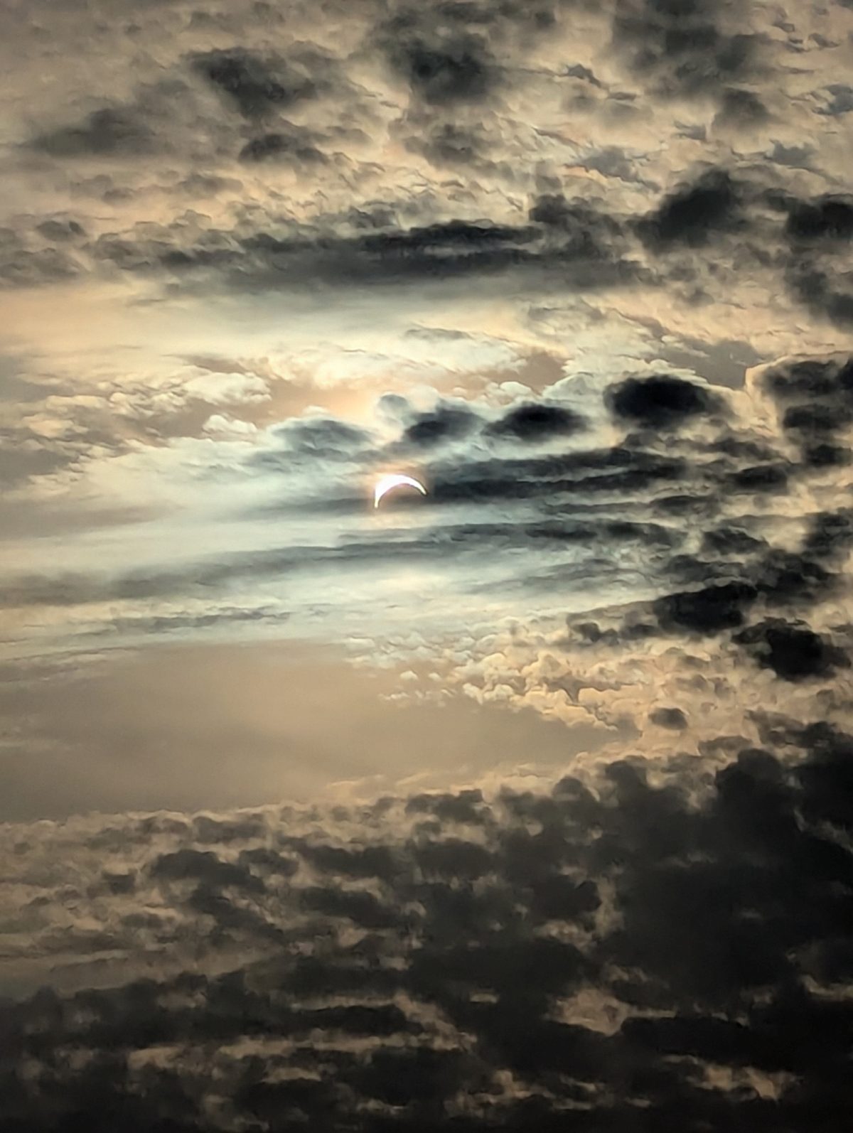 A moody shot of the partial solar eclipse through the clouds, captured by Catherine Potter from Heysham, Lancashire, UK pointing west across Morecambe Bay, 12 August 2026. Equipment: Google Pixel 6 smartphone
