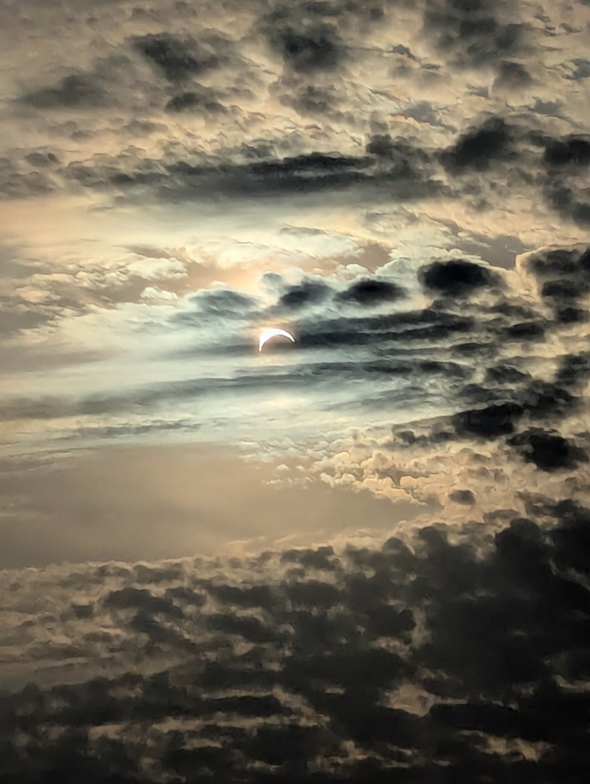 A moody shot of the partial solar eclipse through the clouds, captured by Catherine Potter from Heysham, Lancashire, UK pointing west across Morecambe Bay, 12 August 2026. Equipment: Google Pixel 6 smartphone