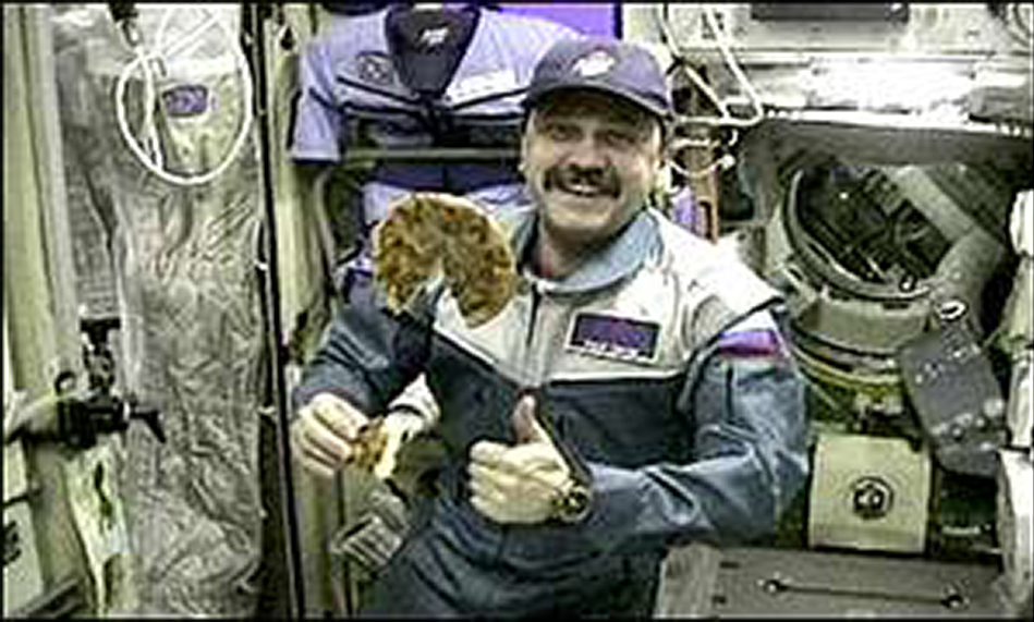 Cosmonaut Yuri Usachov pictured with his Pizza Hut pizza on the International Space Station.