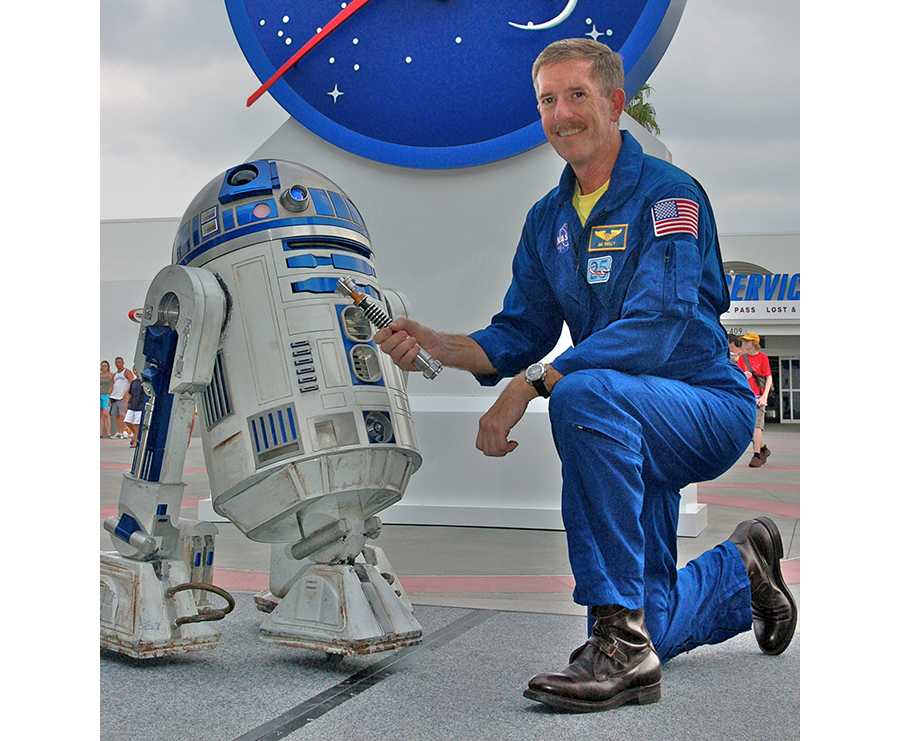 NASA astronaut Jim Reilly welcomes R2-D2 and Luke Skywalker's lightsaber to Kennedy Space Center, ahead of its launch aboard Discovery during STS-120. Credit: NASA