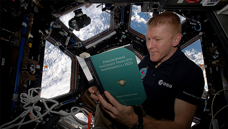 UK astronaut Tim Peake takes time out for some background reading, tackling Isaac Newton's Philosophiæ Naturalis Principia Mathematica, after which Peake's Principia mission was named. Credits: ESA/NASA