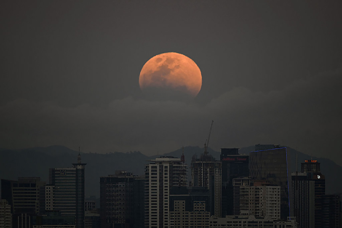 The blood Moon of March 2026 over buildings in Manila in the Philippines. Photo by Ted ALJIBE / AFP via Getty Images