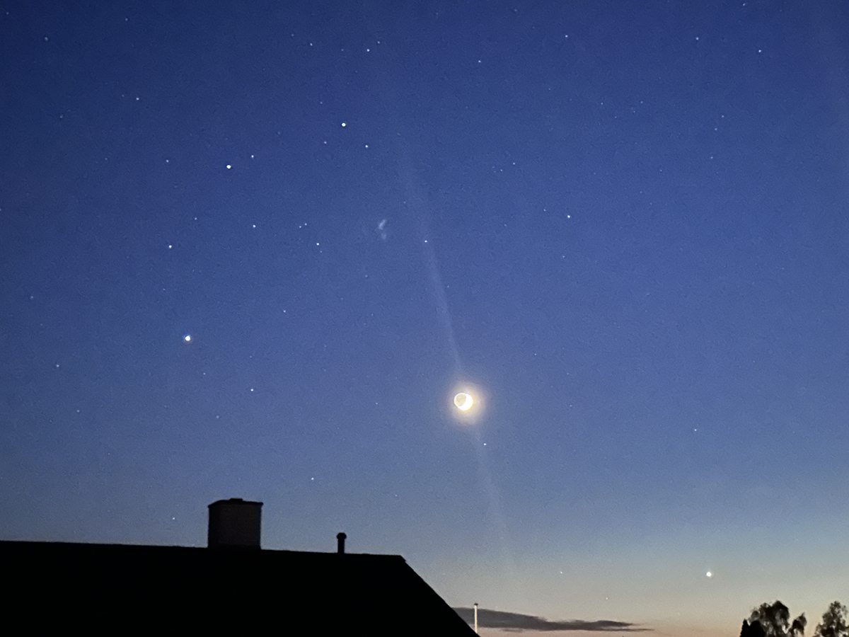 Amanda Millard sent us this view of Venus, the crescent Moon and Jupiter from Fensmark, Zealand, Denmark, 19 May 2026. Venus is on the bottom right of the image. Jupiter is on the left, above the chimney top. The two brightest stars above Jupiter, forming an isosceles triangle with the Moon, are Castor and Pollox, the twin stars of Gemini.