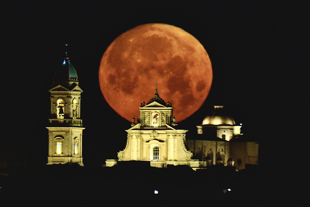 Flower Moon by Giovanni Passalacqua, Basilica della Santissima Annunziata, Ispica, Sicily, 1 May 2026, 05:23 local time. Equipment: Canon EOS R DSLR camera, Sigma 600mm lens, Manfrotto tripod. Exposure: f/6.3, ISO 400, 0.8s. Software: Photoshop