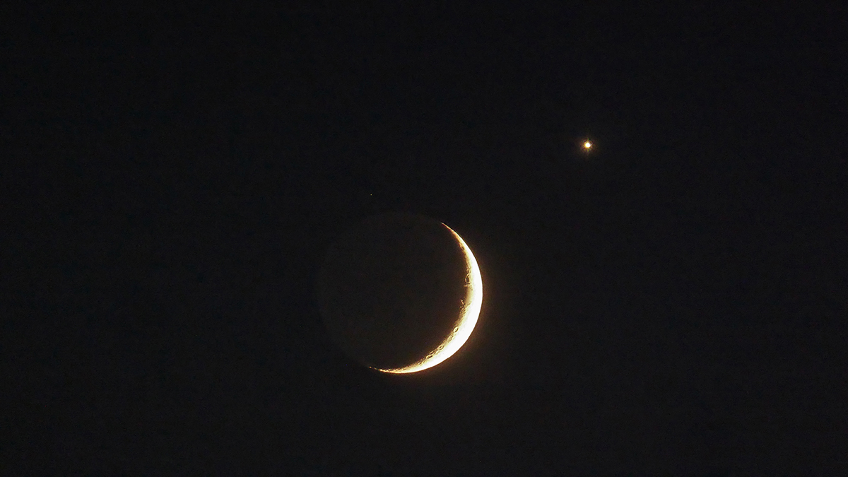 A close-up shot of Venus and the crescent Moon captured by James M from Ryetop Playing Fields, Rainham, Kent, UK, 17 June 2026, 22:50 local time. Jame says: "The tiny white dot above the Moon is the magnitude +5.3 star Eta Cancri." Equipment: Panasonic DMC-TZ60 camera Exposure: ISO 1600, f/6.4, 1/6s, Software: Photoshop