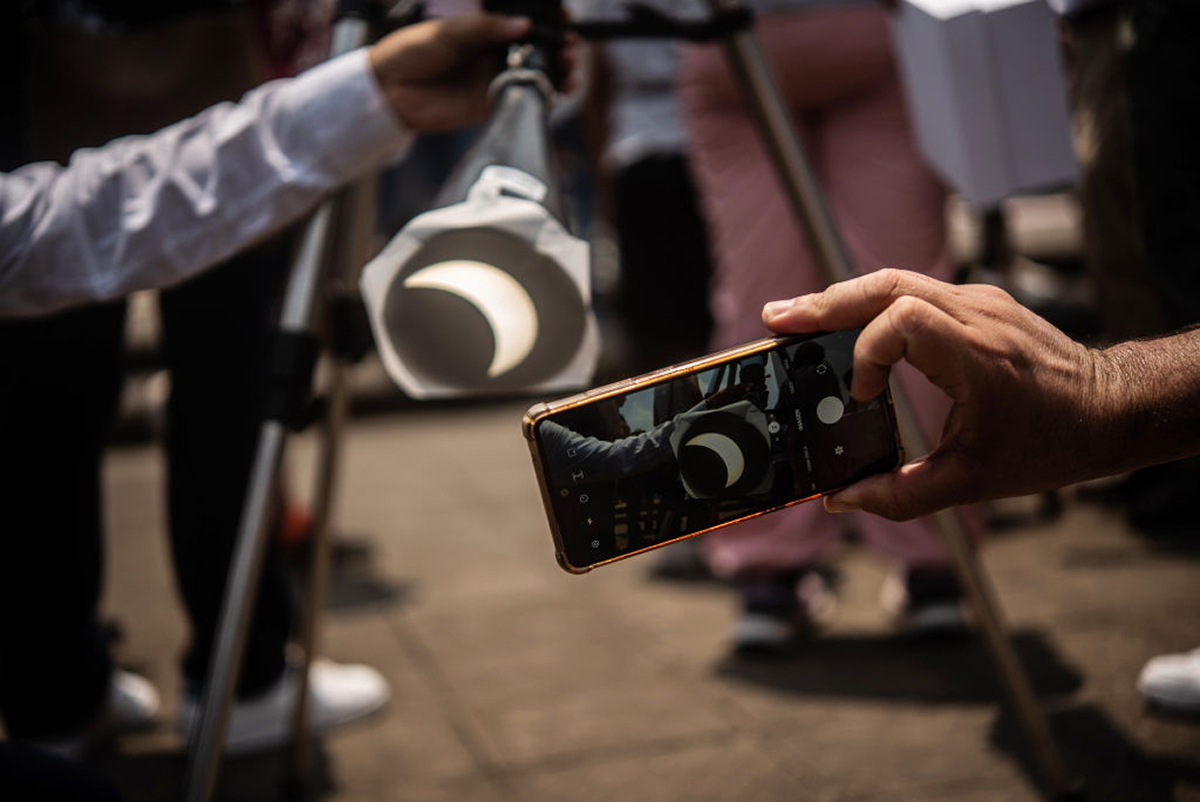An eclipse-watcher photographs a projection of the April 8 eclipse with their smartphone, Veracruz, Mexico. Credit: Hector Quintanar/Getty Images