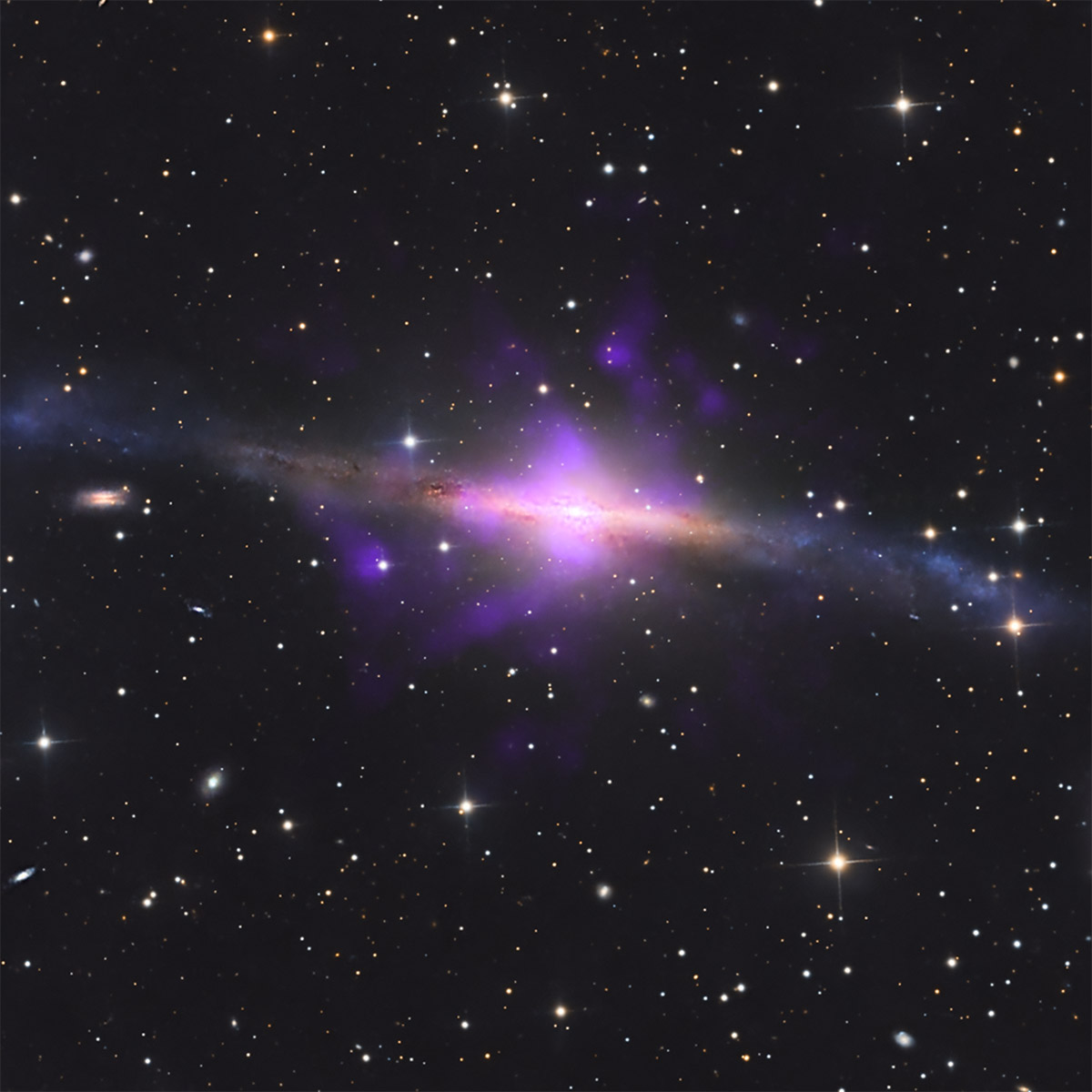 Galaxy NGC 5084, using data from the Chandra X-ray Observatory over a visible-light image of the galaxy. Chandra’s data, in purple, shows four plumes of gas coming from a supermassive black hole rotating on its side at the galaxy’s core. Credit: X-ray: NASA/CXC, A. S. Borlaff, P. Marcum et al.; Optical full image: M. Pugh, B. Diaz; Image Processing: NASA/USRA/L. Product